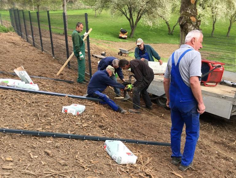 Gruppe „Weibern packt an“ arbeitet  am Freizeitbad Brohltal Teilstück von Zaun erneuert
